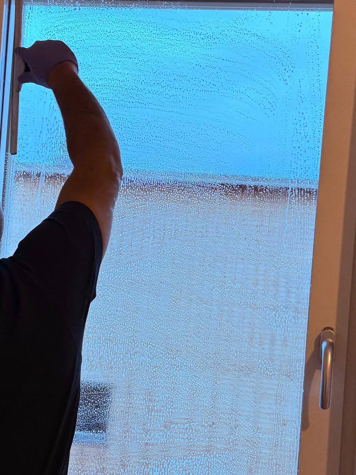 Professionell fönsterputsare arbetar på stora fönster